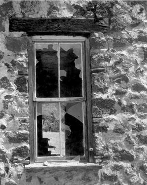 Now the house is empty. Through shards of glass the passer-by glimpses another house.