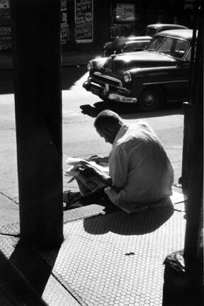 Untitled (man on steps reading paper)