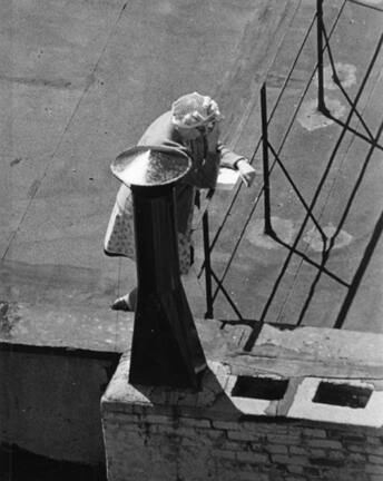 Untitled (woman in hair net reading on roof)