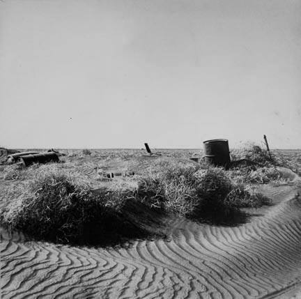 Fence almost completely buried under drifts of soil. Near Liberal, Kansas