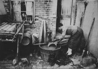 Slum backyard water supply, Washington, D.C. Backyard typical to a group of houses very close to the House office building, showing only available water supply