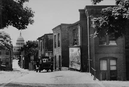 Slums near the Capitol, Washington, D.C. With the Capitol clearly in view, these houses exist under the most unsanitary conditions; outside privies, no inside water supply and overcrowded conditions