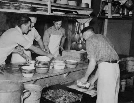 Dishing out and serving food in logging camp near Effie, Minnesota