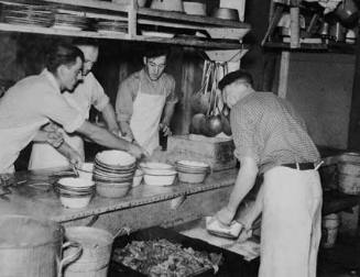 Dishing out and serving food in logging camp near Effie, Minnesota