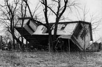 Upturned farmhouse resting against a tree. Result of the flood in Posey County, Indiana