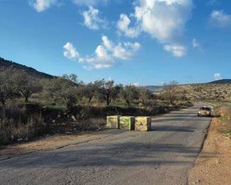 Yellow cab and roadblocks next to checkpoint, West Bank