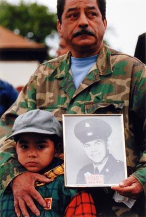 A Child and His Uncle Attend the Annual Southeast Side Vietnam Veterans Memorial While Holding a Photo of a Family Member, Joseph Quiroz, Outside of Our Lady of Guadalupe Parish. Quiroz Died While Serving his Country in Vietnam, September 2000