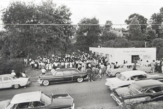The mass meeting in Danville is so crowded that it overflows out into the yard. When word arrives that heavily armed police and an armored vehicle are waiting up the road, the crowd disperses, leaving the SNCC workers to exit last