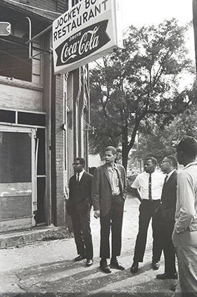 Jimmy Hicks, Julian Bond, John Lewis, and Jeremiah X stand across the street from the bombed church