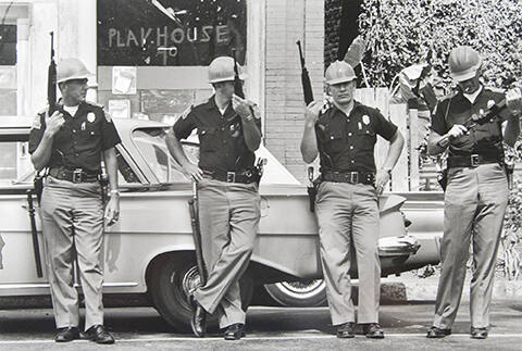 The morning after the bombing of the Sixteenth Street Baptist Church, heavily armed members of the Alabama Highway Patrol make a show of force near the [bombed Sixteenth Street Baptist] church. The bomb exploded next to the wall and up through the floor of a Sunday school class. Four girls were buried in the bathroom and died.