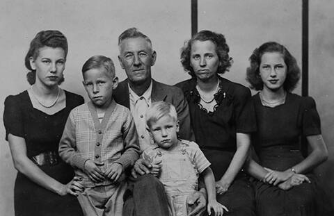 Untitled (seated six-person family, striped background)