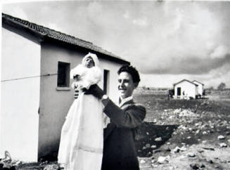 Eliezer Trito shows parental pride with the “first child,” Miriam Trito, born into the settlement, a daughter he had with his wife Miria, Italian settlement of Alma, Northern Galilee Israel, from the "Magnum Founders: In Celebration of 60 Years" portfolio