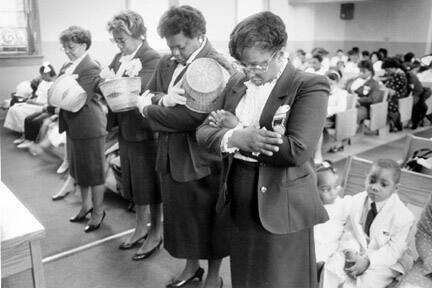 Women Worshippers After Helping in the Collection Bow Their Heads in Prayer