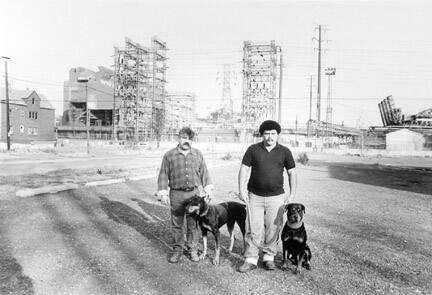 Two Men and Their Dogs on an Abandoned Steel Mill Parking Lot