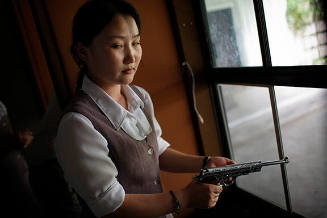 A North Korean woman loads a Pistol for firing practice in Pyongyang, North Korea on Aug. 18, 2007