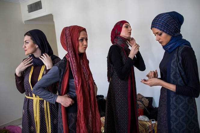 Tehran, Iran. A group of models apply makeup before a photo shoot.