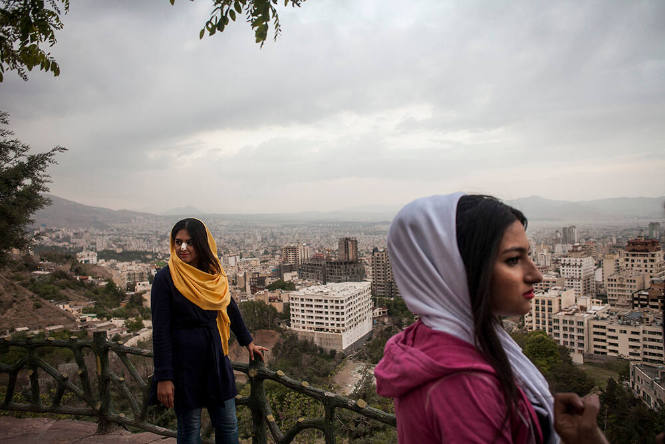 Tehran, Iran. A group of young women stand on a terrace at Bam-e Tehran, the 'roof of Tehran,' an area overlooking the capital. One of the young women has a dressing on her nose following plastic surgery. Iran has the highest rate of nose surgery in the world with a reported 200,000 operations taking place each year.