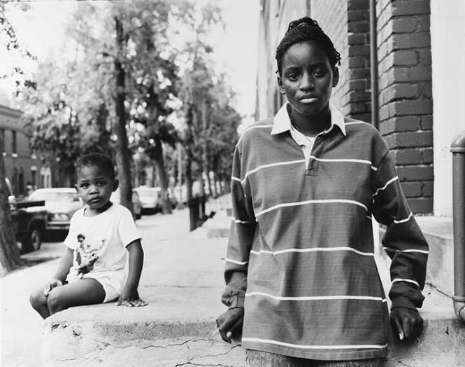 A Girl and Boy Sitting on a Stoop