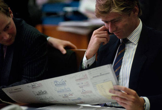 GB. ENGLAND. London. Lloyds of London. An Underwriter examines a slip