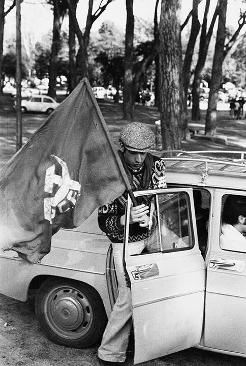 Demonstrator with Communist Union flag getting into a car to go to manifestation held at Vallecas, workers area near Madrid, Spain