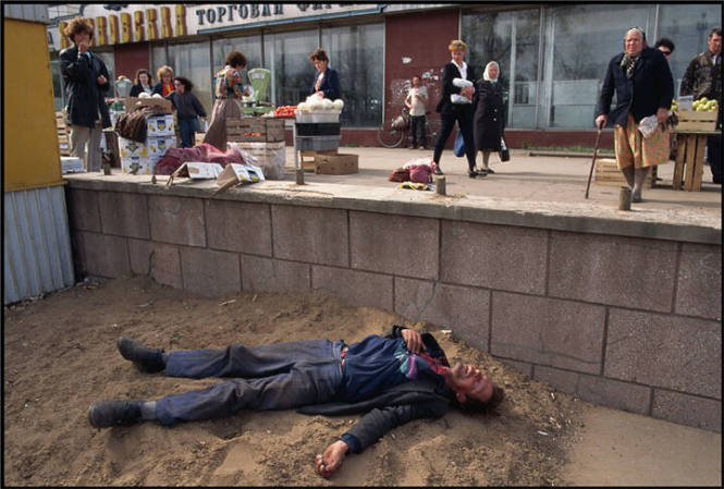 Drunk man lying in the dirt near a market, Kirov, Russia