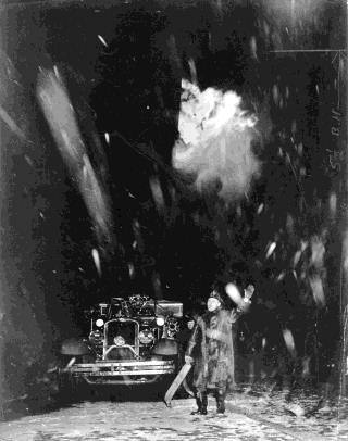 Untitled (fireman in front of firetruck in snow at night)