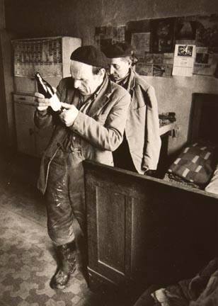 Untitled (man looking at bottle), from the "Village Photo" series