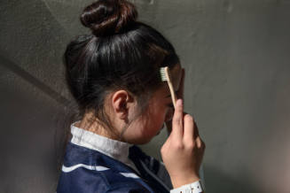 Teen brushing baby hairs during a dance competition