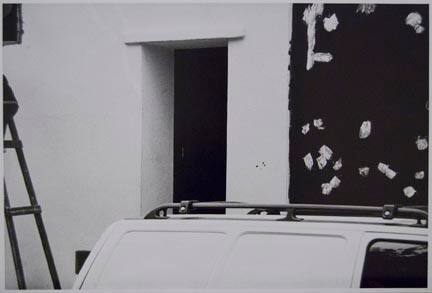 Untitled (top of vehicle next to black/white wall)