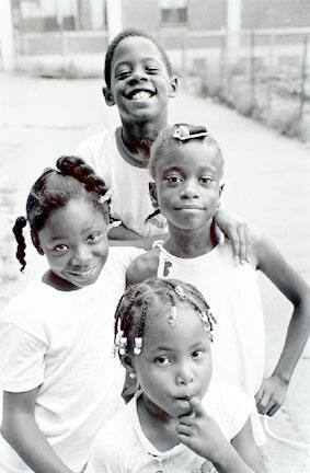 Three girls and boy outside 929 N Hudson, Cabrini-Green, from Changing Chicago