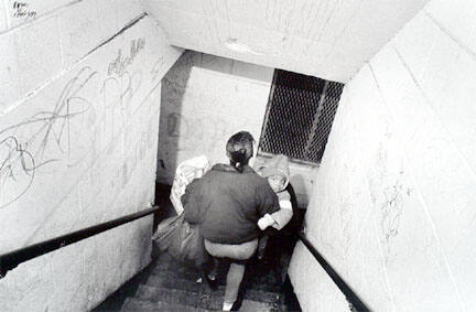 Woman with groceries and child going downstairs, Cabrini-Green, from Changing Chicago