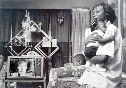 Woman holding young girl while boy watches white woman on TV, Cabrini-Green, from Changing Chicago