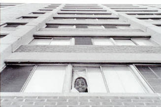 Veronique Lee looking out high-rise window, Cabrini-Green, from Changing Chicago